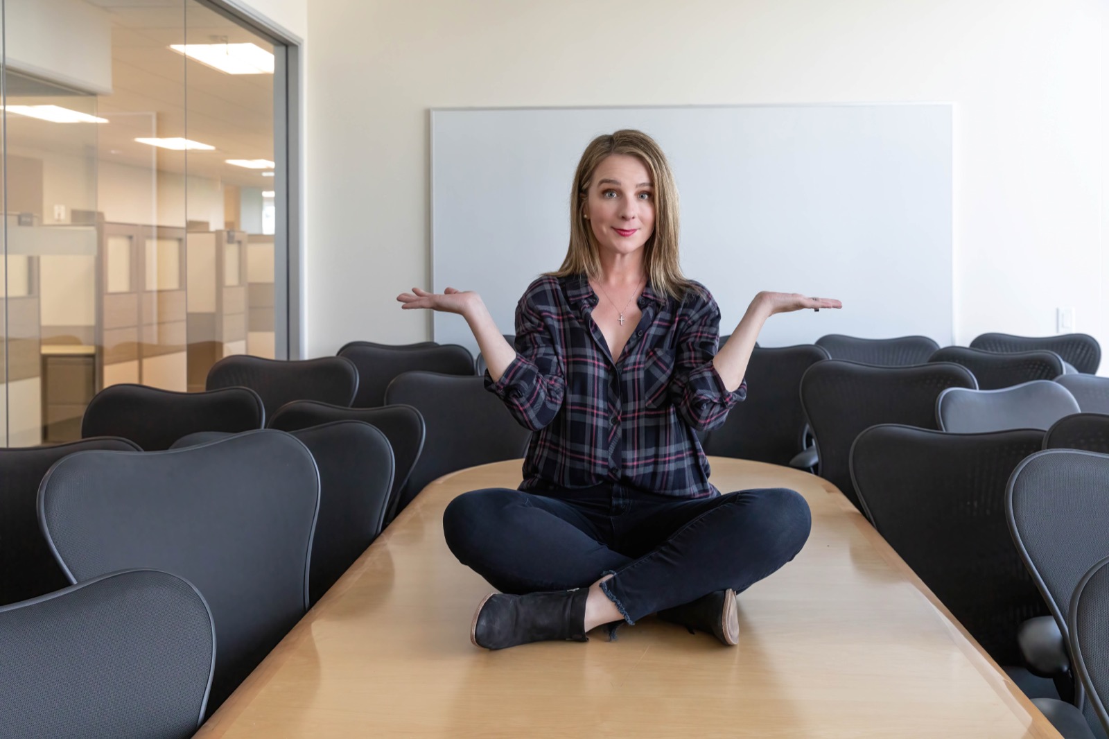 Brandi Susewitz, RESEAT co-founder, seated on a conference table surrounded by second-life task chairs